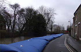 Temporary flood barriers installed along a river to control flooding